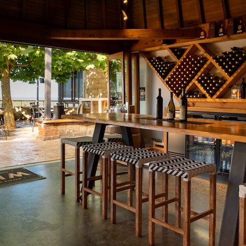 Our cellar door showing the wine collection and the view over the bush and the ocean